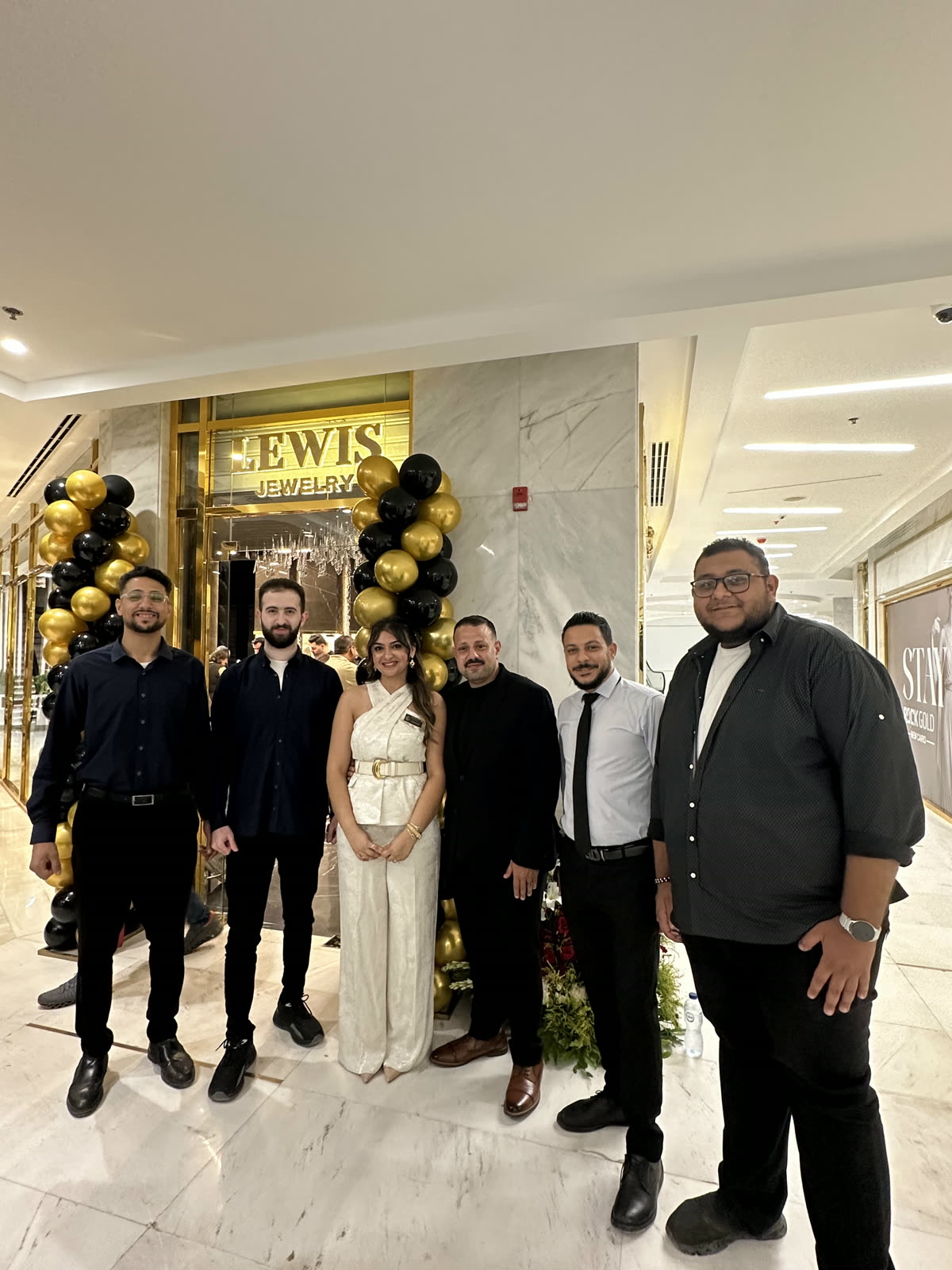 فريق SWH أمام واجهة متجر Lewis Jewelry الجديد يوم الافتتاح.