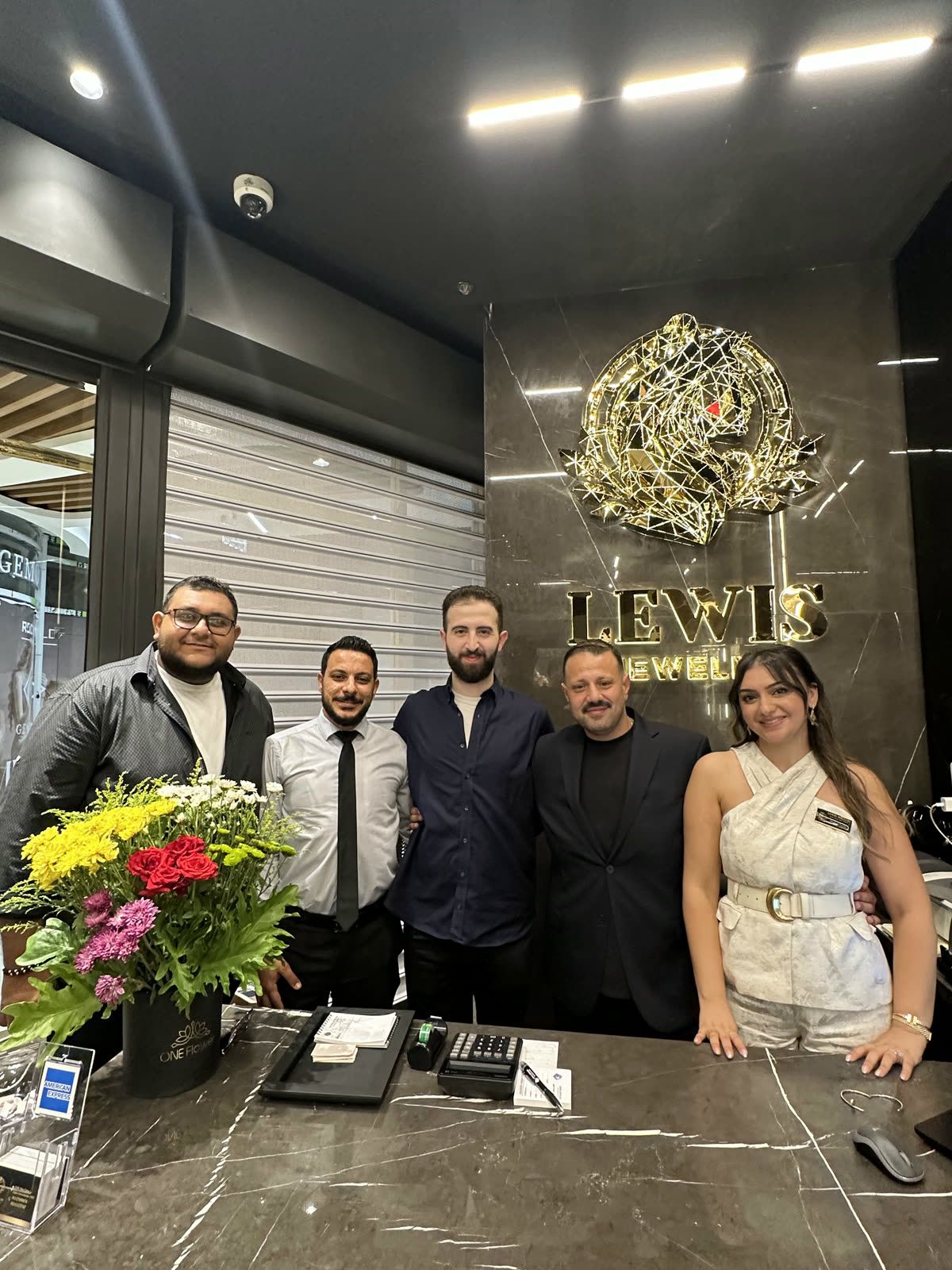فريق التنفيذ عند منضدة Lewis Jewelry أثناء الافتتاح الكبير.