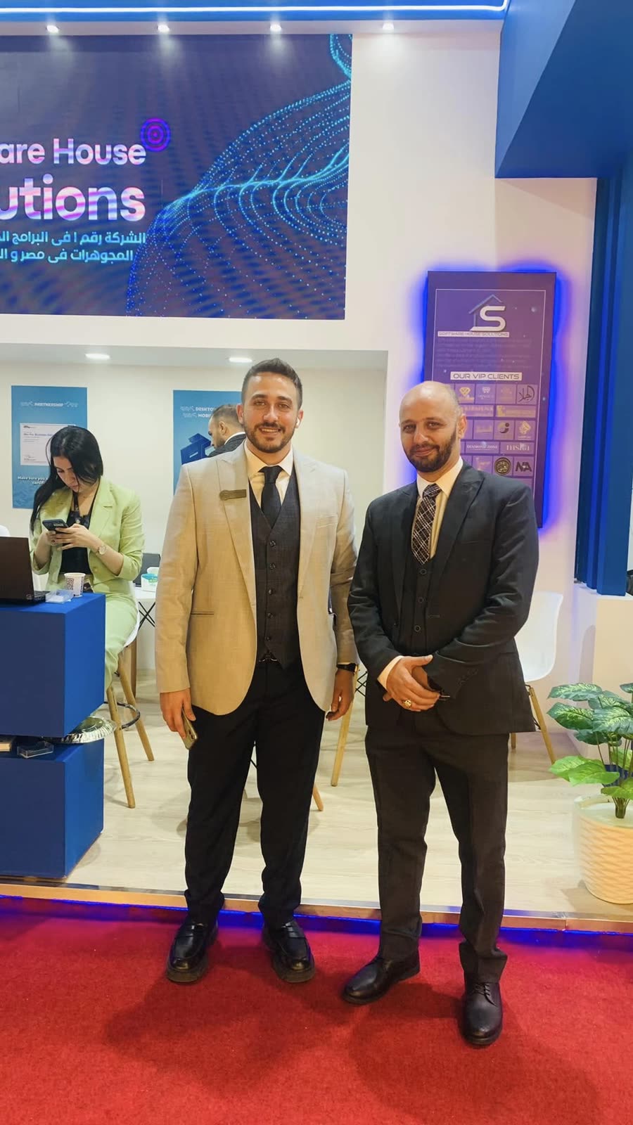 عضوان من فريق Software House Solutions في جناح الشركة خلال معرض NEBU 2023.