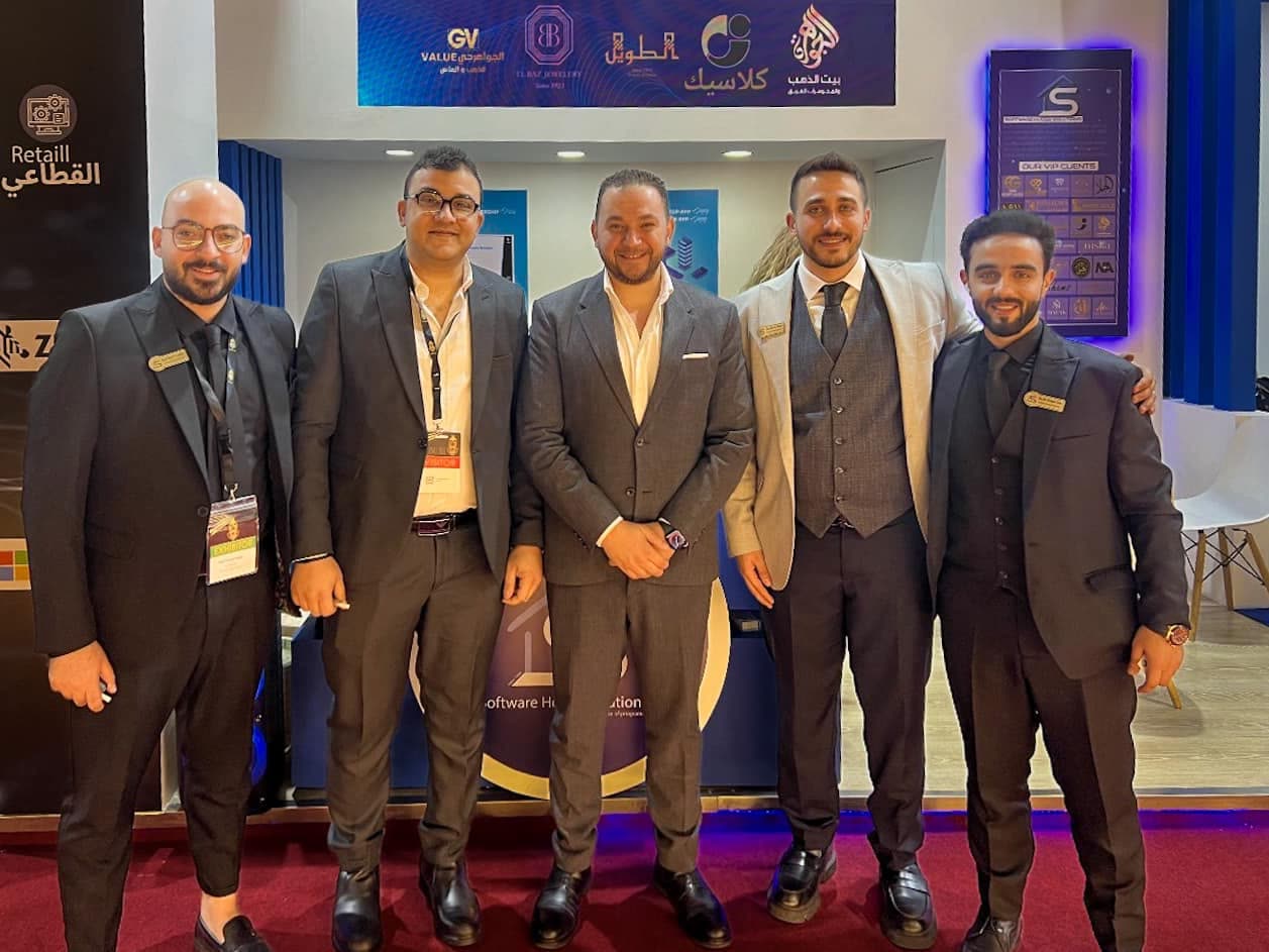 خمسة من أعضاء فريق SWH أمام عرض العملاء في معرض NEBU 2024.