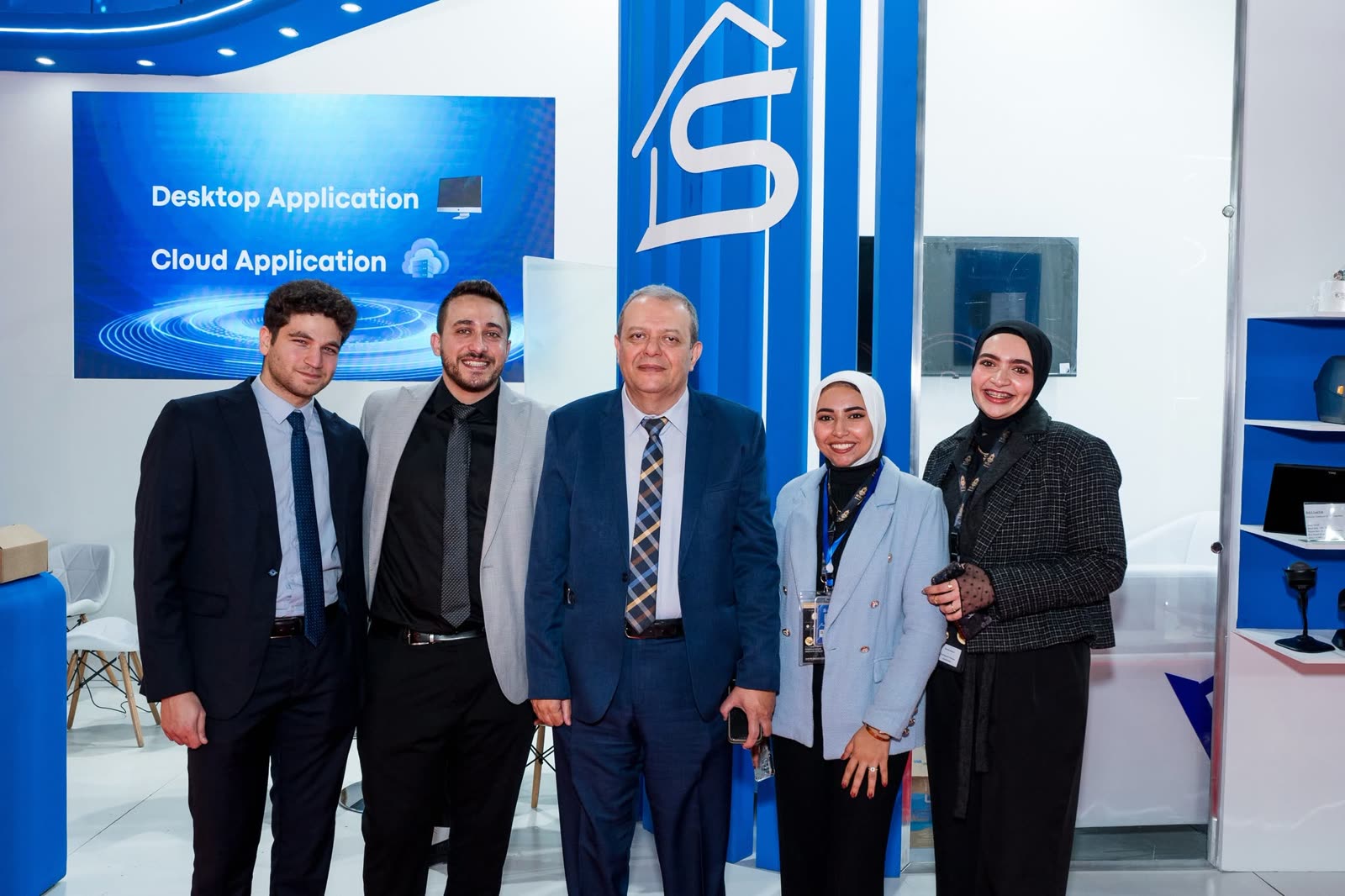زملاء SWH بجوار لوحة تطبيقات سطح المكتب والسحابة في الجناح بمعرض NEBU 2024.