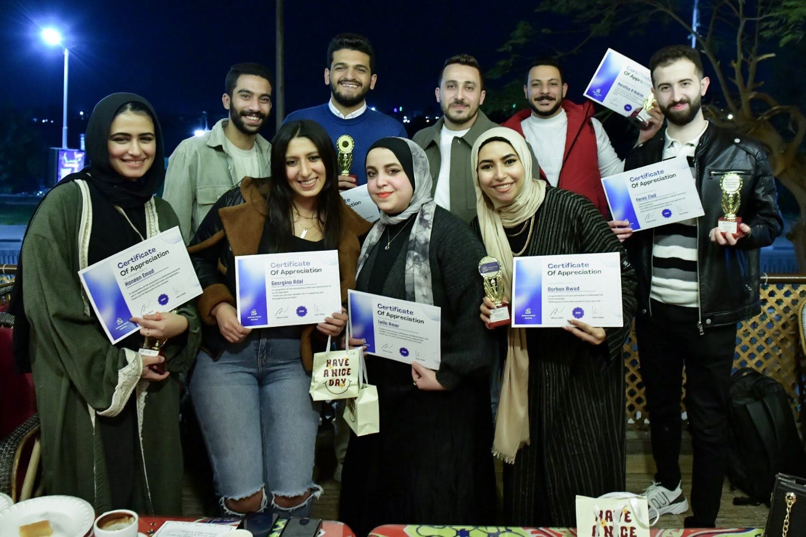 زملاء يحملون شهادات التقدير في رحلة رمضان.